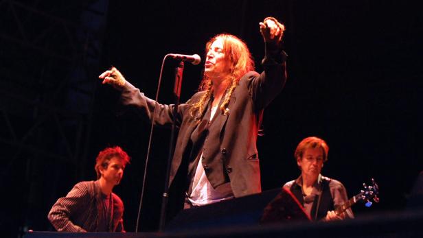Patti Smith tritt mit ihrer Band auf einer Bühne auf.