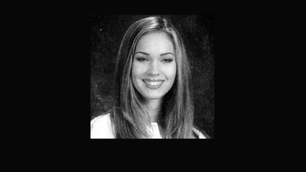 Ein Schwarzweißporträt von Megan Fox, lächelnd in die Kamera.