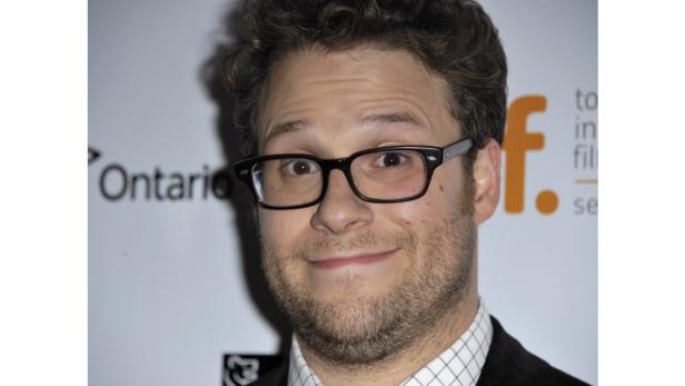 Porträt von Seth Rogen mit Brille vor einem Veranstaltungslogo.