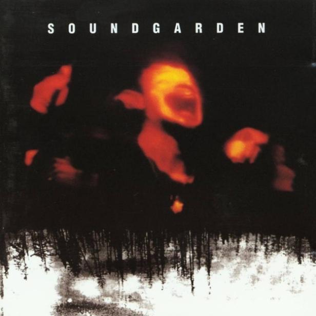 Das Albumcover von Soundgarden zeigt verzerrte, rote Gesichter über einem dunklen Wald.