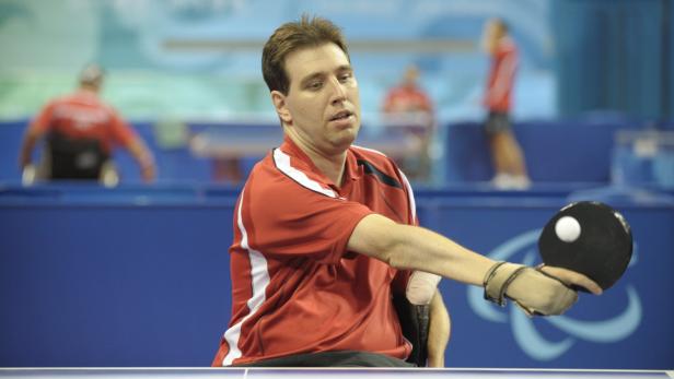 Ein Mann im Rollstuhl spielt Tischtennis.
