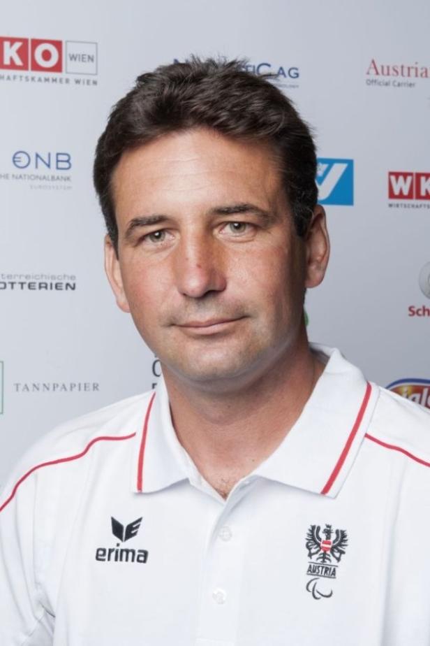 Ein Mann im weißen Poloshirt mit dem österreichischen Bundesadler.