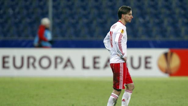 Ein Fußballspieler steht auf dem Feld vor einer „Europa League“-Werbung.
