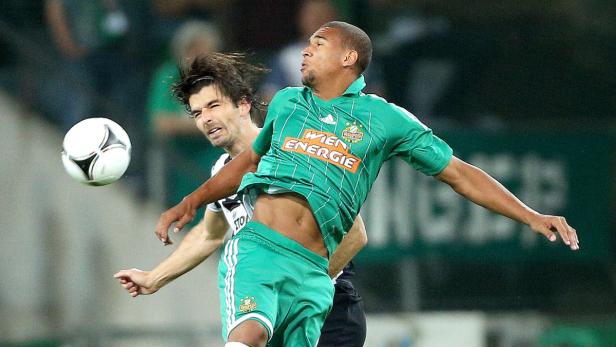 Zwei Fußballspieler kämpfen um den Ball während eines Spiels.