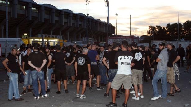 Eine Gruppe von Fußballfans versammelt sich vor einem Stadion.