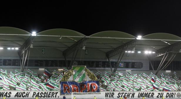 Fans schwenken Fahnen im Stadion des SK Rapid Wien.
