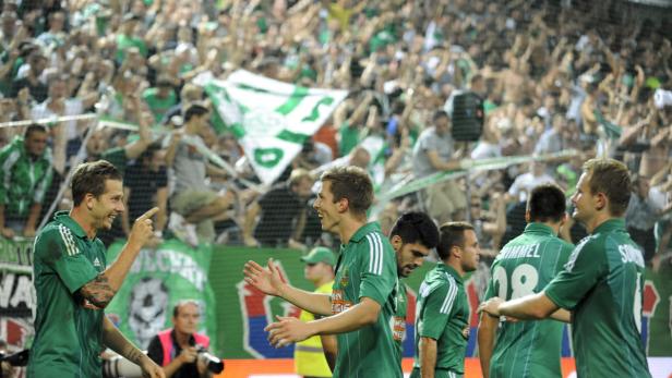 Fußballspieler feiern vor einer jubelnden Zuschauermenge.