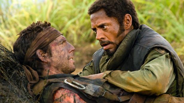 Ein Soldat, der schwere Verletzungen erlitten hat, wird von einem anderen Soldaten im Dschungel versorgt.