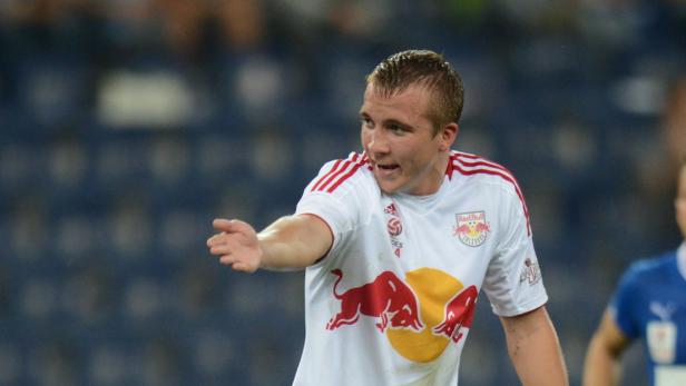 Ein Fußballspieler im Trikot von Red Bull Salzburg gestikuliert auf dem Spielfeld.