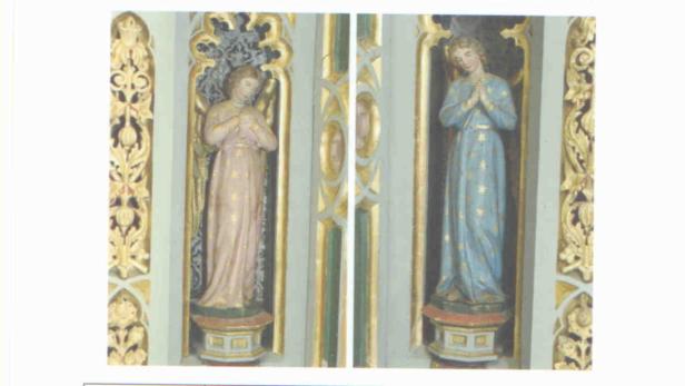 Zwei Statuen von Frauen in verzierten Nischen.