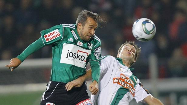 Zwei Fußballspieler kämpfen um den Ball bei einem Fußballspiel.