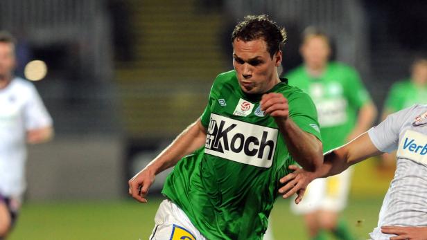 Ein Fußballspieler in einem grünen Trikot während eines Spiels.