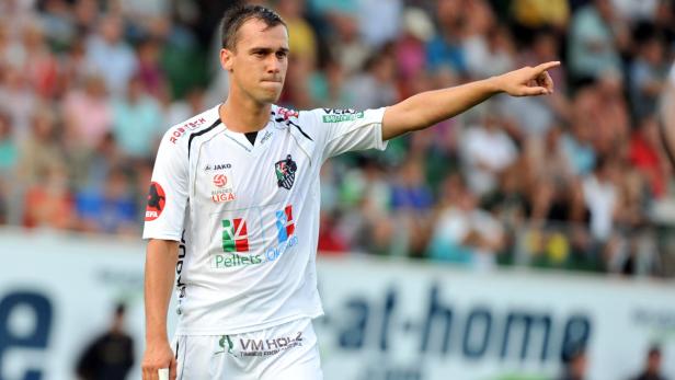 Ein Fußballspieler in weißem Trikot zeigt mit dem Finger in eine Richtung.