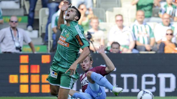 Zwei Fußballspieler kämpfen um den Ball während eines Spiels.