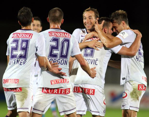 Fußballspieler der Mannschaft Austria Wien feiern gemeinsam auf dem Spielfeld.