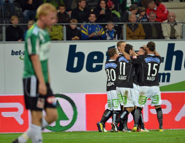 Fußballspieler feiern ein Tor auf dem Spielfeld.