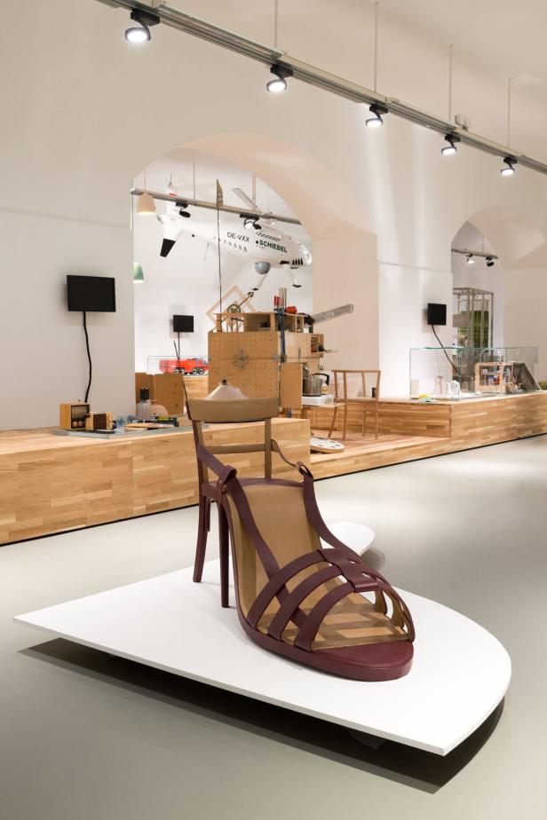 Ein überdimensionaler Damensandalen-Stuhl steht in einer Museumsausstellung.