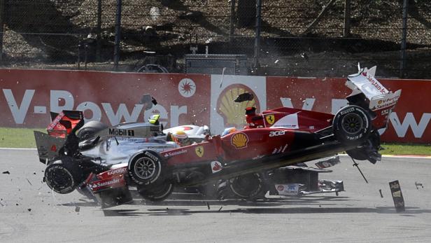 Ein schwerer Unfall zwischen einem Ferrari und einem Mercedes-Benz Formel-1-Wagen auf einer Rennstrecke.