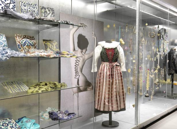 Eine Vitrine mit traditioneller Tracht, Tüchern und Schmuckstücken.