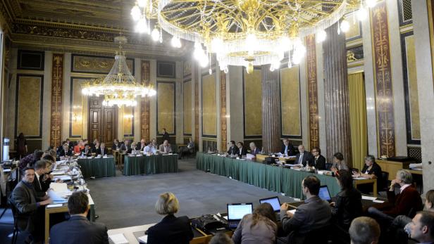 Ein großer Konferenzraum mit Personen, die an Tischen sitzen und arbeiten.