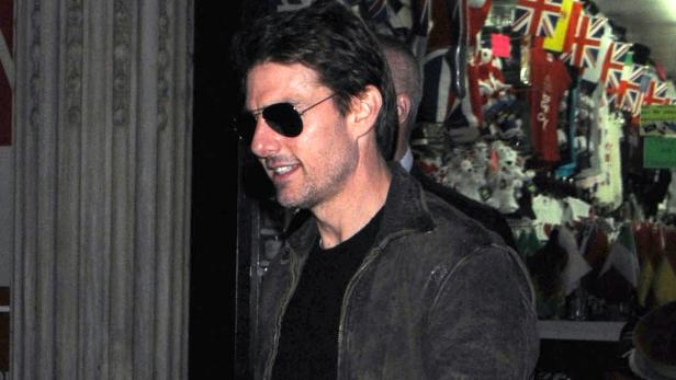 Tom Cruise mit Sonnenbrille und Jacke vor einem Souvenirladen in London.