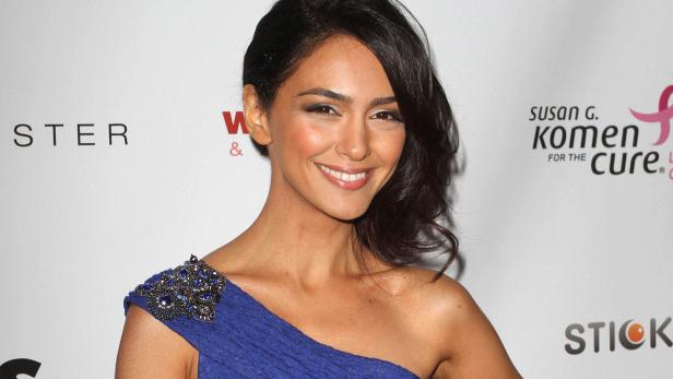 Schauspielerin Necar Zadegan lächelt in einem blauen Kleid auf einer Veranstaltung.