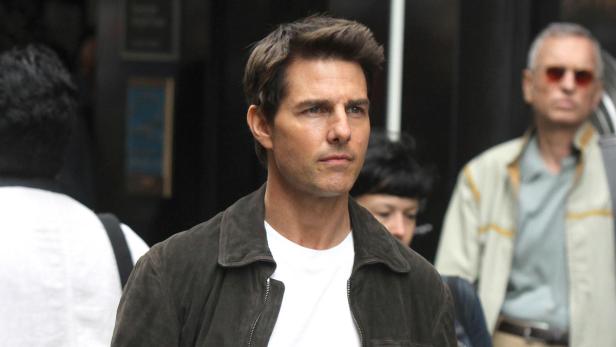 Tom Cruise trägt eine braune Jacke und ein weißes T-Shirt.