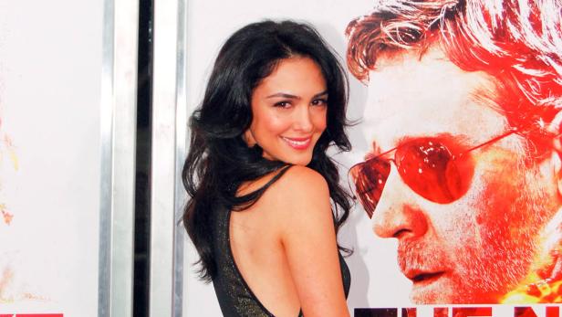 Schauspielerin Nazanin Boniadi posiert vor einem Filmposter.