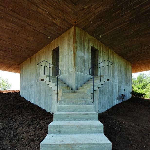 Ein Betongebäude mit zwei Treppen, die zu jeweils einer Tür führen.