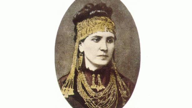 Porträt einer Frau mit aufwendigem Kopfschmuck und Halsketten.