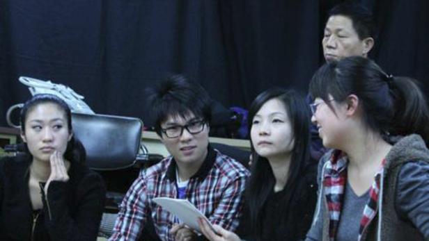 Eine Gruppe junger Leute sitzt zusammen und scheint sich zu unterhalten.