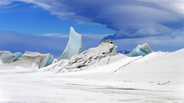 Eine eisige Landschaft mit Gletschern unter einem blauen Himmel.