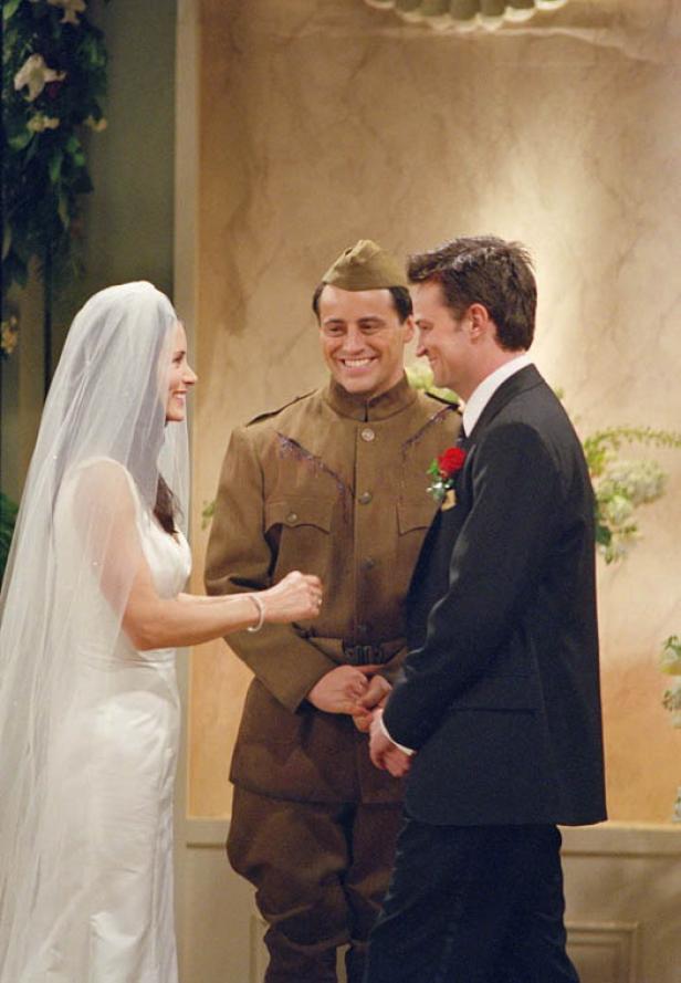 Monica und Chandler heiraten in der Serie „Friends“, während Joey in einem Weltkriegs-Outfit die Trauung vollzieht.