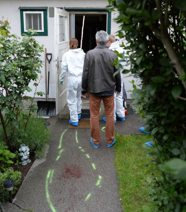Spurensicherung untersucht einen Tatort vor einem Haus.