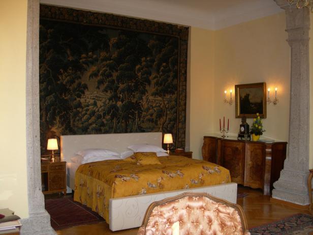 Ein Schlafzimmer mit einem großen Wandteppich über dem Bett.