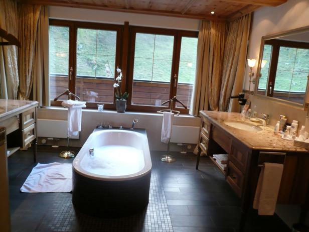 Ein Badezimmer mit einer freistehenden Badewanne vor einem Fenster.