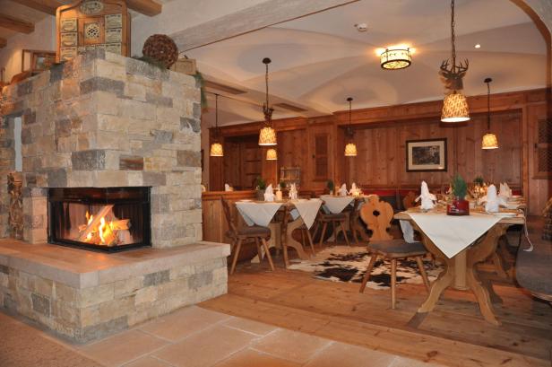 Ein gemütliches Restaurant mit Holztäfelung und einem Kaminfeuer.