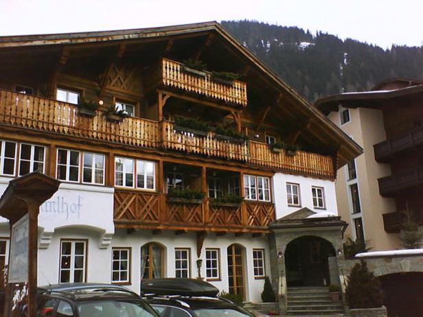 Ein traditionelles Hotel im alpenländischen Stil mit Holzbalkonen und weißen Wänden.