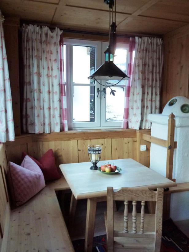 Eine Essecke mit Holztäfelung, Eckbank und einem Tisch mit Äpfeln.