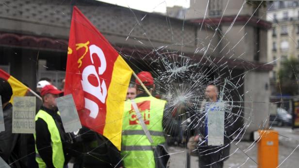 Eine Demonstration der CGT hinter einer zerbrochenen Fensterscheibe.