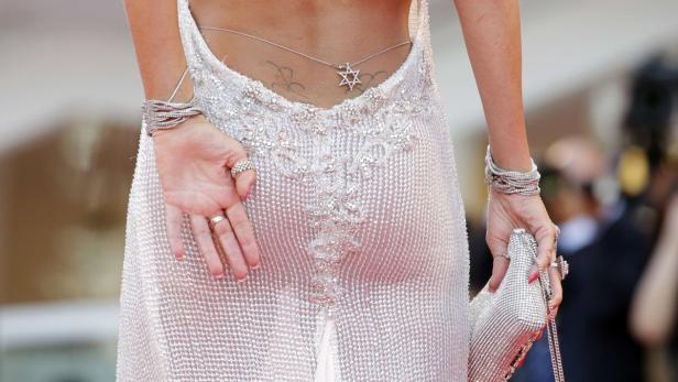 Eine Frau in einem glitzernden Kleid mit Schmuck und einer Halskette mit Davidstern auf dem Rücken.