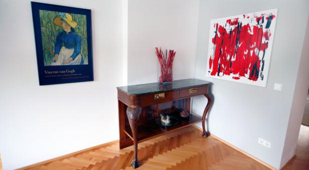 Ein Flur mit einem Gemälde von Vincent van Gogh und einem abstrakten Kunstwerk.