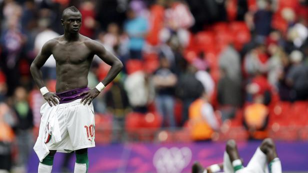 Ein barfüßiger Fußballspieler mit der Nummer 10 steht auf dem Spielfeld.