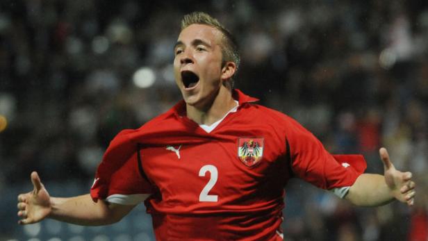 Ein österreichischer Fußballspieler jubelt mit offenem Mund und erhobenen Armen.