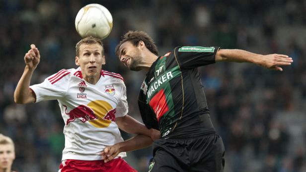 Zwei Fußballspieler kämpfen um den Ball mit ihren Köpfen.