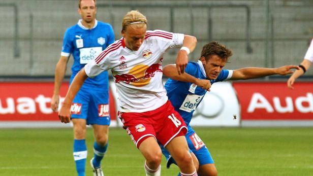 Zwei Fußballspieler kämpfen um den Ball während eines Spiels.