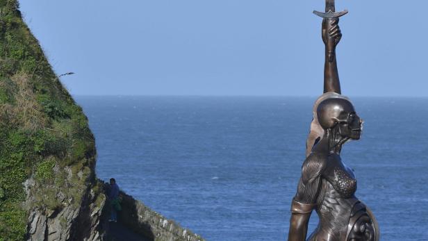 Die Skulptur „Rebirth“ von Damien Hirst in Ilfracombe, England, mit Meer im Hintergrund.