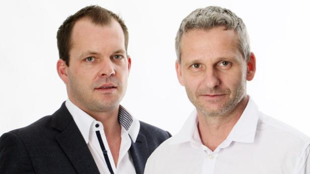 Zwei Männer posieren vor einem weißen Hintergrund.