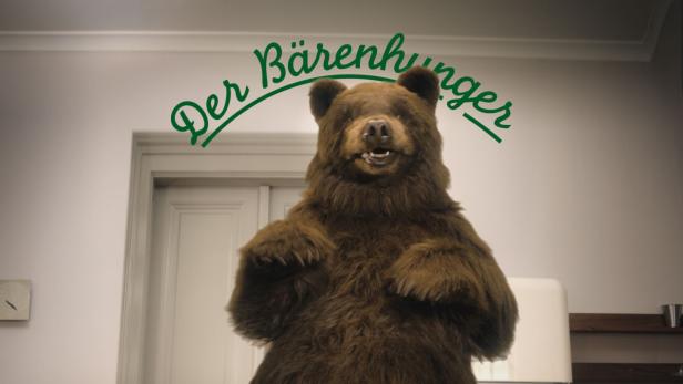 Ein Bär steht in einem Raum mit dem Schriftzug „Der Bärenhunger“ darüber.