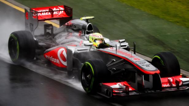 Ein Formel-1-Rennwagen von McLaren fährt im Regen auf einer Rennstrecke.